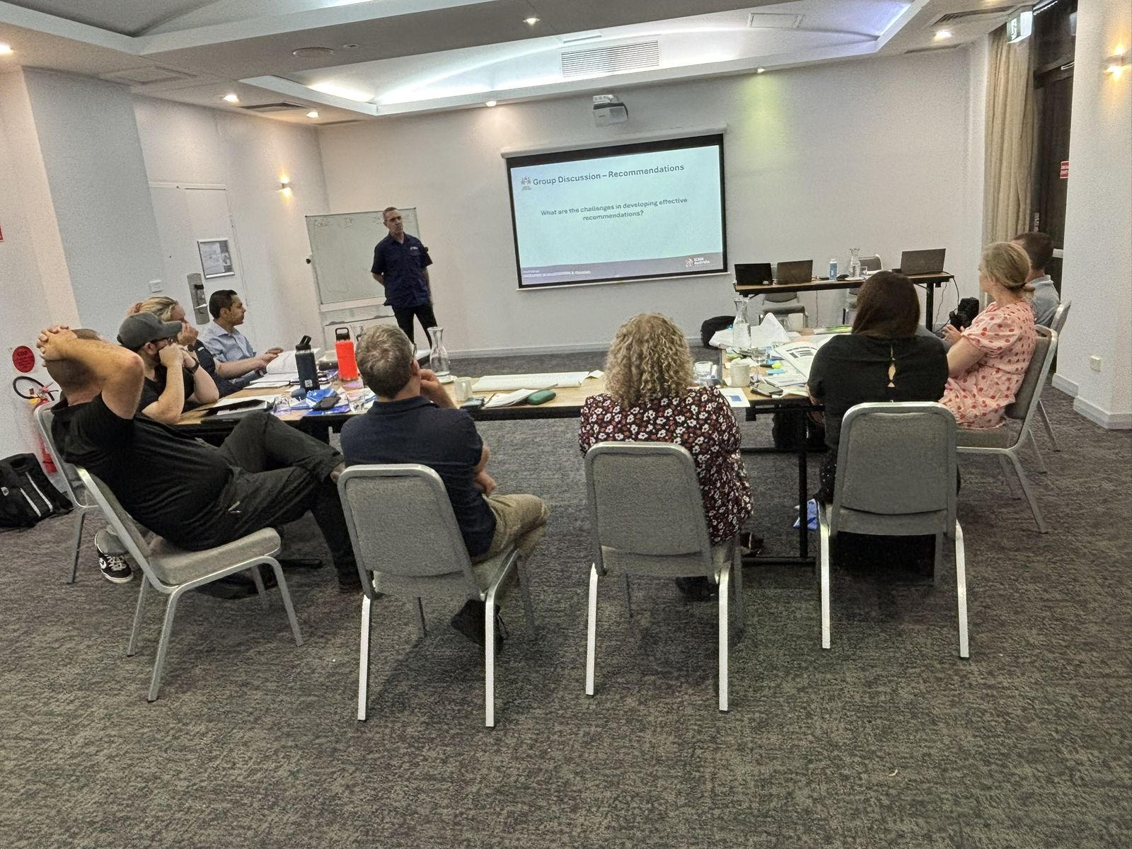 A facilitator presenting an ICAM slide to a room of managers